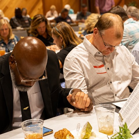 Leaders praying together around a table
